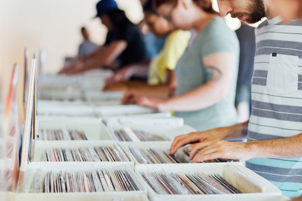 A number of people browse the record bins at a record shop
